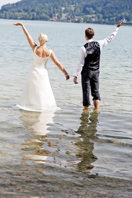 Germany, Bavaria, Tegernsee, Wedding couple standing in lake, wearing hand cuffs