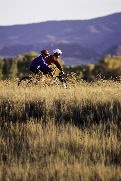 Cycling Cycling, Couple mountain biking in Fall., by Copyright 1994 DUOMO