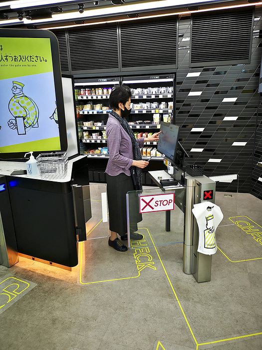 Autonomous convenience store, Tokyo, Japan Editorial use only   Woman paying for goods at a cashierless checkout in an autonomous convenience store at Takanawa Gateway Station, Tokyo, Japan. The store uses artificial intelligence to recognize customer behaviour, and it prevent shoplifting by accurately recognizing when merchandise is taken from the shelves.