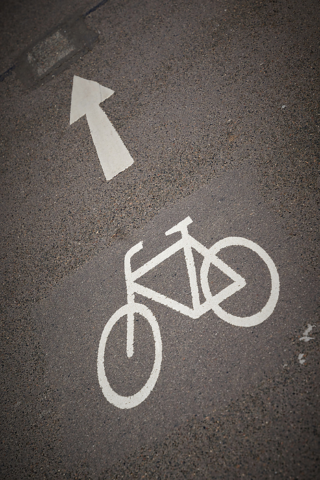 Road marking on asphalt to indicate a bicycle lane with directional arrow Road marking on asphalt to indicate a bicycle lane with directional arrow, by Zoonar Heiko Kueverl