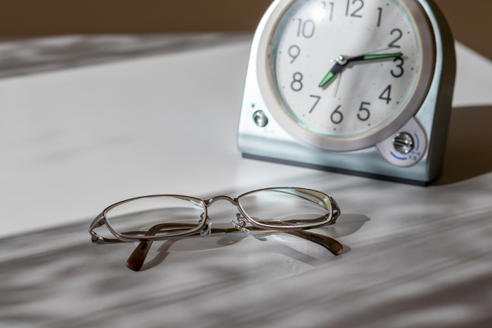 Clock and glasses on the desk by the window