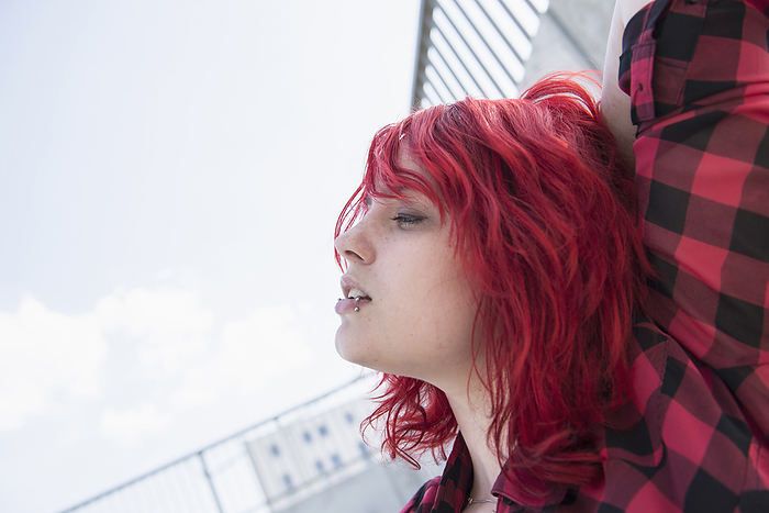 Portrait day-dreaming teenage girl red dyed hair, by Cavan Images / Edith Drentwett