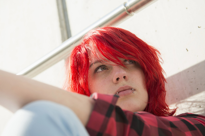 Lonely young teenage girl dyed hair piercings, by Cavan Images / Edith Drentwett