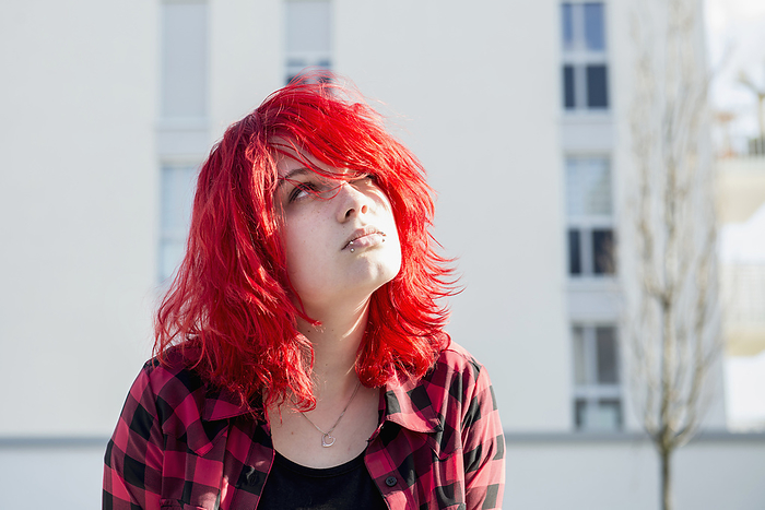 Teenager girl bright red hair day-dreaming, by Cavan Images / Edith Drentwett
