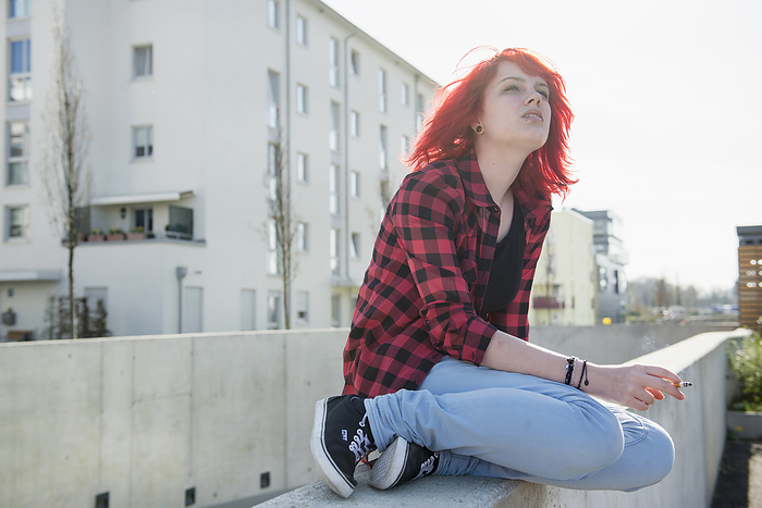 Independent teenage girl thinking sitting alone, by Cavan Images / Edith Drentwett