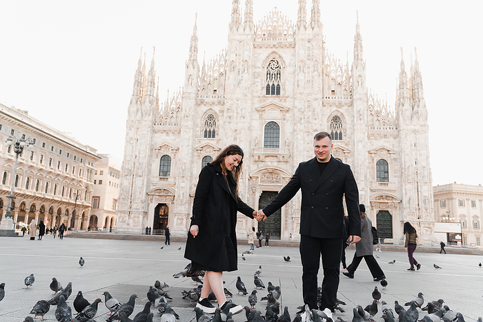 Stylish couple in love walking on Duomo square in Italy, by Cavan Images / Liza Zavialova