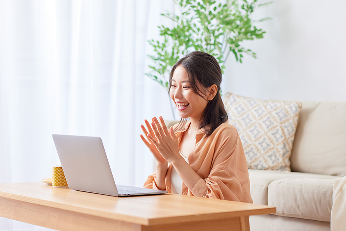 Japanese woman applauding at the computer.