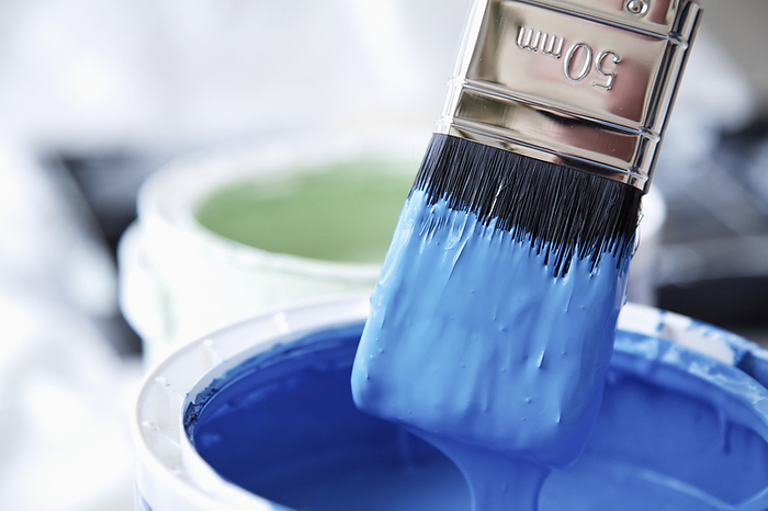 Close up of blue paint pot and dripping paintbrush, by Ableimages