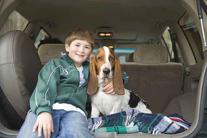 Boy and Basset Hound in Back of SUV, by Albert C. Karges / Design Pics