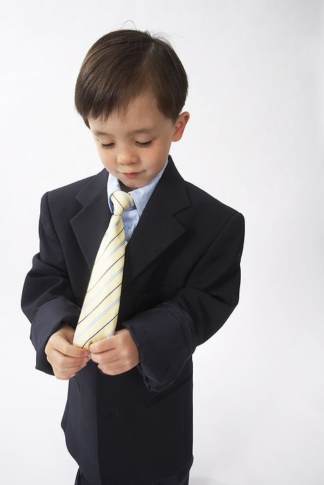 Little Boy Dressed Up as a Businessman Looking at His Tie, by Edward Pond / Design Pics