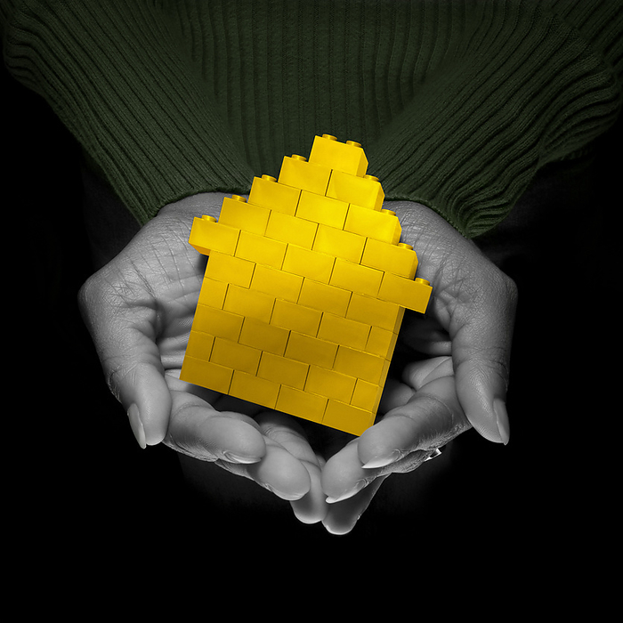 Close-up of Woman's Hands holding Yellow Brick House, Studio Shot, by Gary Rhijnsburger / Design Pics
