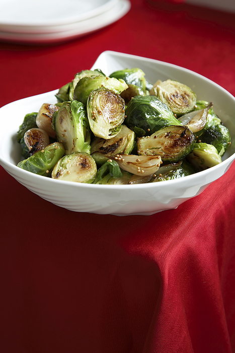 Brussel sprouts in bowl on red backround, by Jodi Pudge / Design Pics