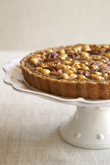 Mixed nut tart on a crockery cake stand, by Jodi Pudge / Design Pics