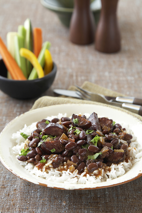 Black beans with sausage on rice served with raw vegetable sticks, by Jodi Pudge / Design Pics
