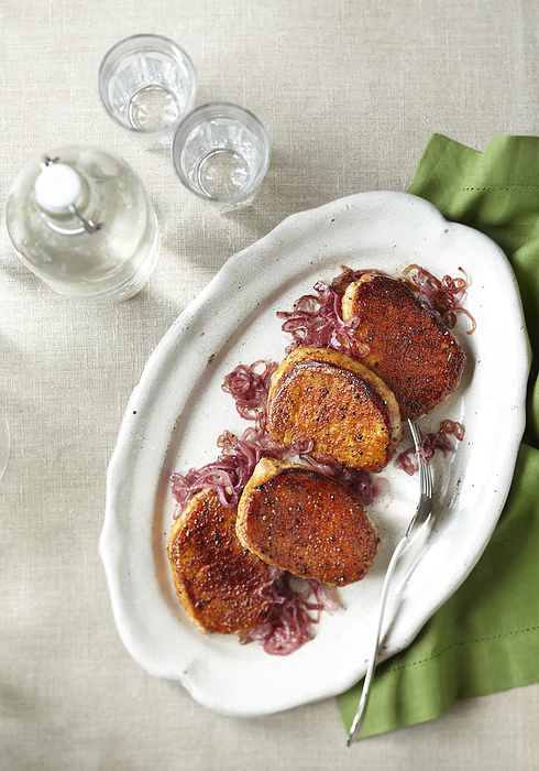 Pork chops with caramelized red onions on a serving platter, by Jodi Pudge / Design Pics