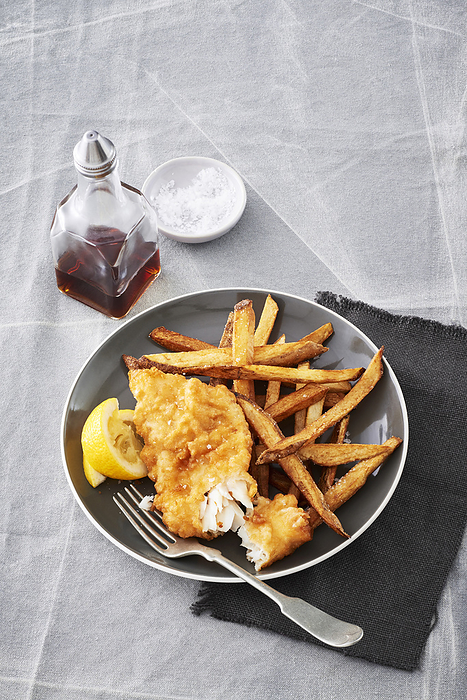 Fish and chips with malt vinegar on a grey backround, by Jodi Pudge / Design Pics