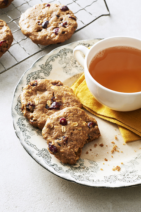 Cranberry oat breakfast cookies on a decorative plate with a cup of herbal tea, by Jodi Pudge / Design Pics