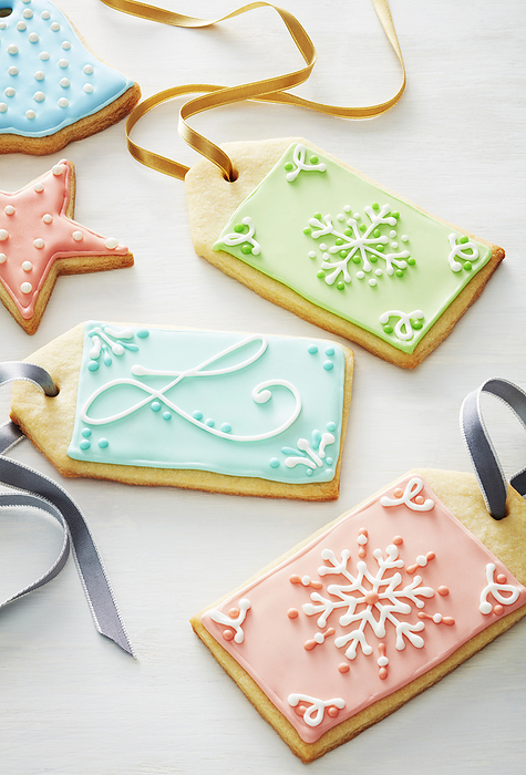 Close-up of festive sugar cookie gift tags decorated in pastel colors on a white background, by Jodi Pudge / Design Pics