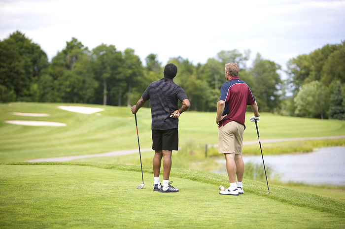 Backview of Men Standing on Golf Course, by Mark Leibowitz / Design Pics