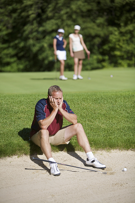 Man Sitting by Sand Trap on Golf Course, by Mark Leibowitz / Design Pics