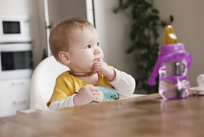 Baby in High Chair Eating, by I. Jonsson / Design Pics