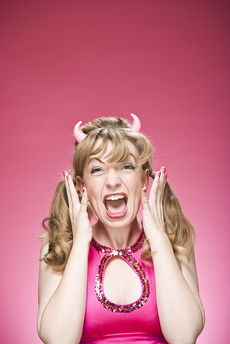 Portrait of Woman Wearing Devil Horns and Screaming, by Mitch Tobias / Design Pics