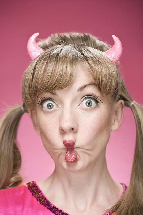 Portrait of Woman Wearing Devil Horns and Making Faces, by Mitch Tobias / Design Pics