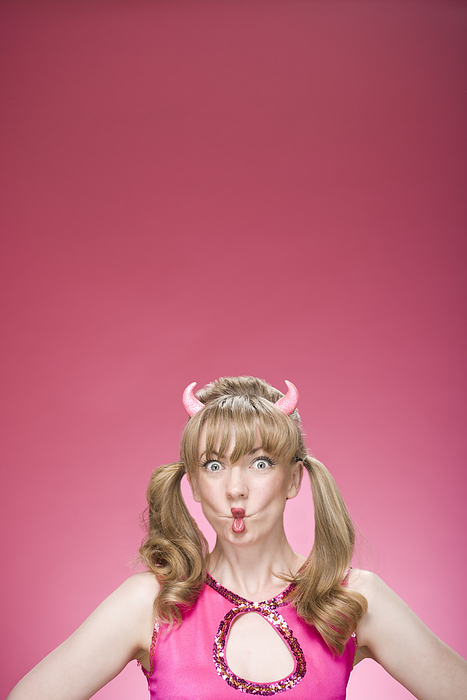 Portrait of Woman Wearing Devil Horns and Making Faces, by Mitch Tobias / Design Pics