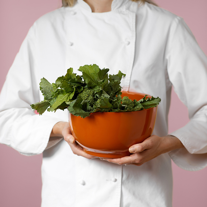 Female Chef holding Bowl of Fresh Rapini Greens, by Natasha Nicholson / Design Pics