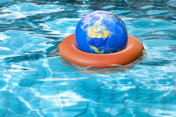 Globe in Life Preserver in Pool, by Norbert Schäfer / Design Pics