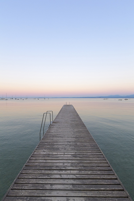 Wooden jetty on Lake Gardo (Lago di Garda) at dawn in Bardolino in Veneto, Italy, by Raimund Linke / Design Pics