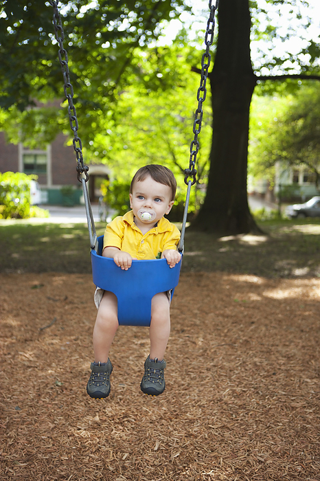 Boy Playing on Swings, Washington Park Playground, Portland, Oregon, USA, by Ty Milford / Design Pics