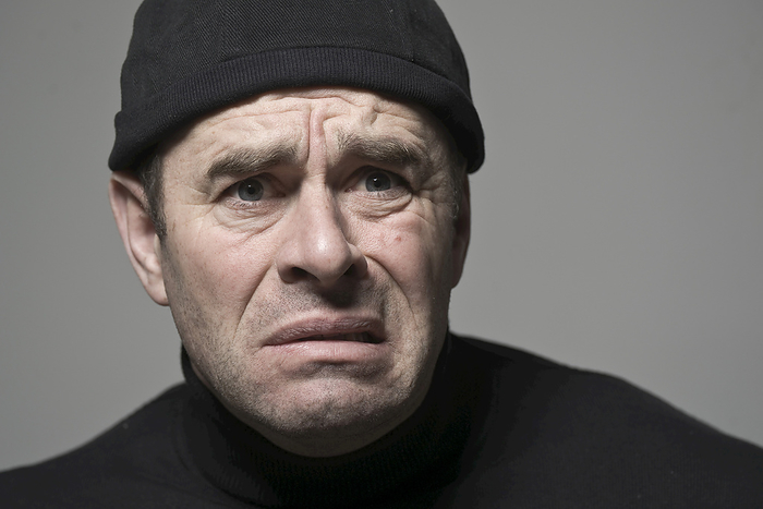 Man in Black Cap Looking Scared, by Uwe Umstätter / Design Pics