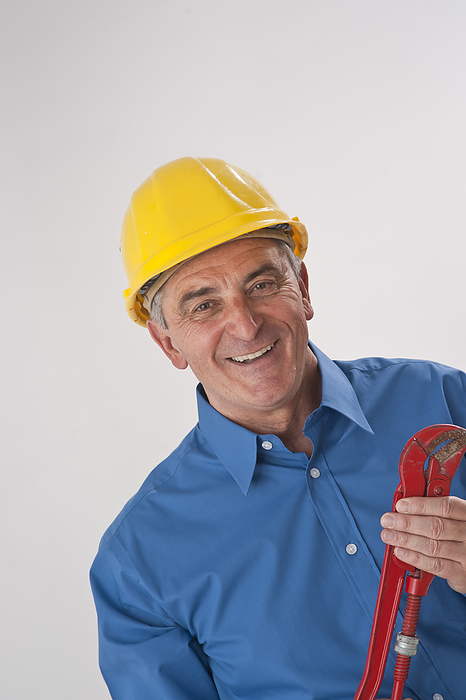 Portrait of Man wearing Hardhat and holding Wrench, by Uwe Umstätter / Design Pics