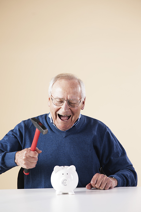 Portrait of Senior Man Breaking Piggy Bank, by Uwe Umstätter / Design Pics