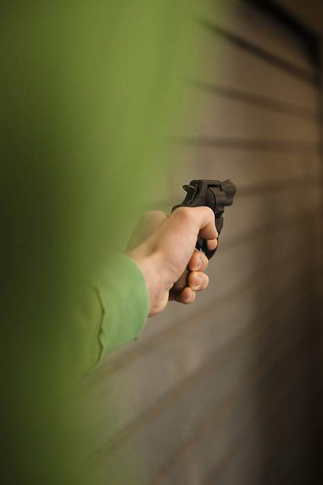 Close-up of Young Man Aiming Handgun, Mannheim, Baden-Wurttemberg, Germany, by Uwe Umstätter / Design Pics
