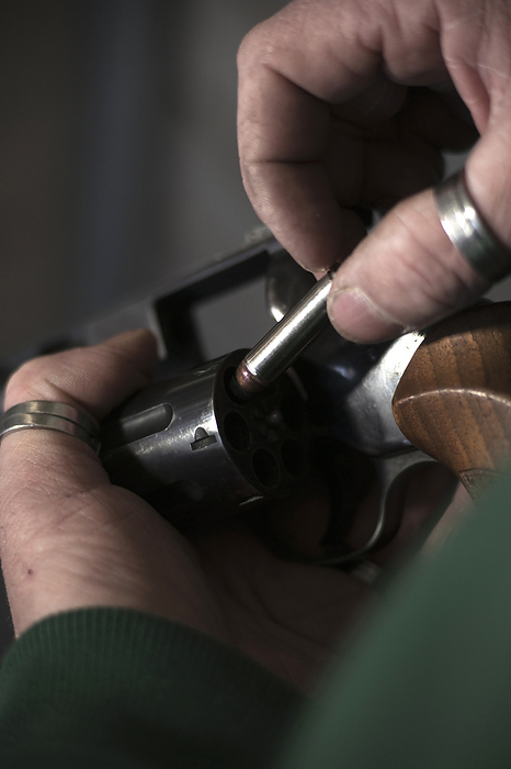 Close-up of Man Loading Bullets into Gun, Mannheim, Baden-Wurttemberg, Germany, by Uwe Umstätter / Design Pics