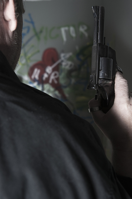 Close-up of Man holding Gun with Graffiti in Background, Mannheim, Baden-Wurttemberg, Germany, by Uwe Umstätter / Design Pics