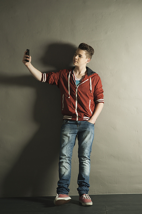 Teenager with Cell Phone, Studio Shot, by Uwe Umstätter / Design Pics