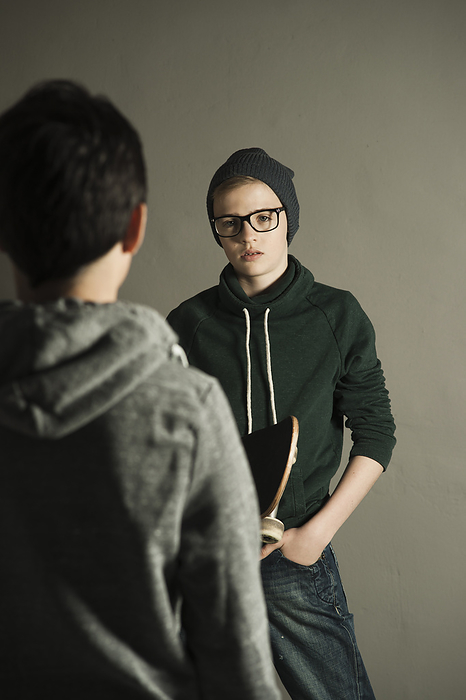 Boy with Skateboard talking to Teenage Boy, Studio Shot, by Uwe Umstätter / Design Pics