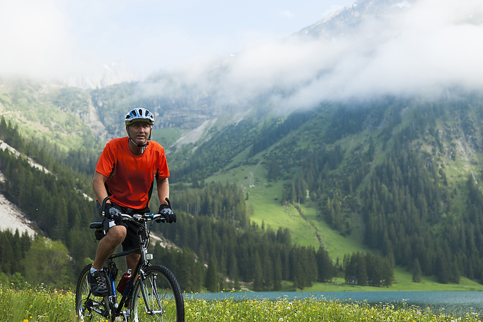Mature Man Riding Mountain Bike by Vilsalpsee, Tannheim Valley, Tyrol, Austria, by Uwe Umstätter / Design Pics