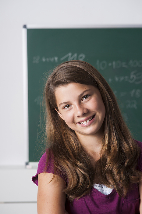 Portrait of girl in classroom, Germany, by Uwe Umstätter / Design Pics