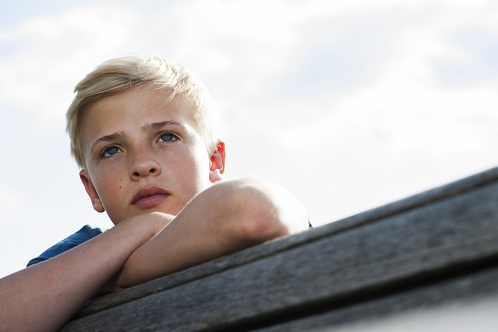 Close-up portrait of boy outdoors, looking into the distance, Germany, by Uwe Umstätter / Design Pics