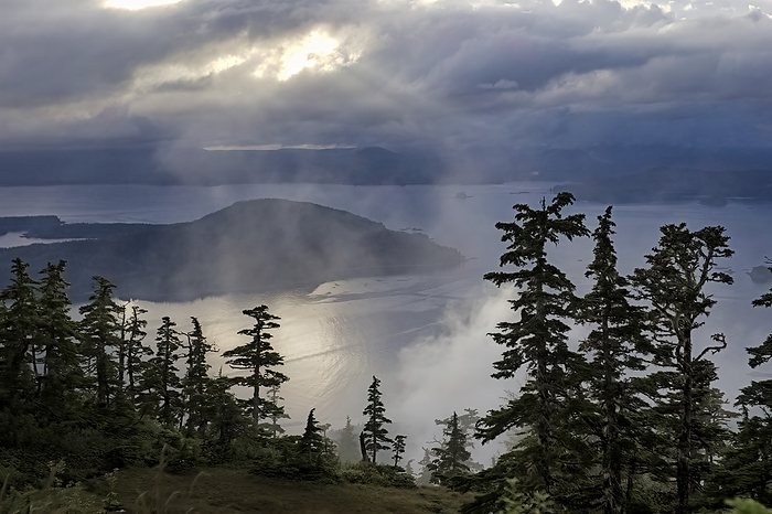 America Rays of sunlight pierce the clouds hanging over Sitka Sound and Baranof Island. Southeast Alaska receives about 200 inches of rain a year creating its moody ambiance  Southeast Alaska, Alaska, United States of America, by Melissa Farlow   Design Pics