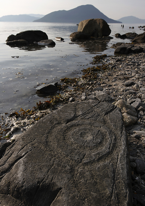 America Petroglyph Beach is a State Historic Site with a collection of petroglyphs carved by Tlingit Native Alaskans. At low tide, the site reveals a series of 40 different rock sketches overlooking the Stikine River and Zimovia Straits  Stikine River, Alaska, United States of America, by Melissa Farlow   Design Pics