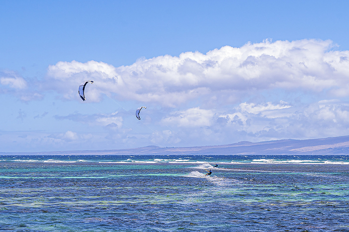 Maui, Hawaii Two kitesurfers riding the waves off the coast of Shipwreck Beach in Lanai with the Island of Maui in the distance  Hawaii, United States of America, by Living Moments Media   Design Pics