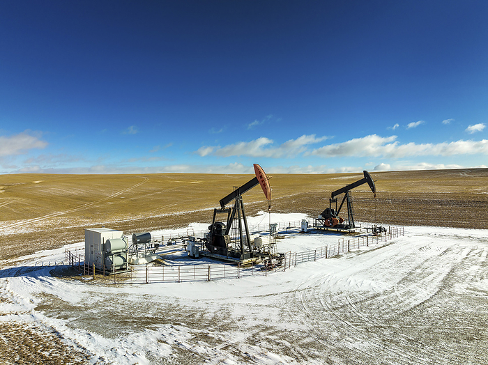 Canada Aerial view of pumpjacks in a snow covered field with dramatic clouds in a blue sky with clouds, West of Airdrie  Alberta, Canada, by Michael Interisano   Design Pics