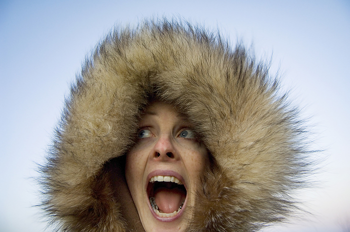 Woman battles the cold in a fur-trimmed winter coat; Lincoln, Nebraska, United States of America, by Joel Sartore Photography / Design Pics