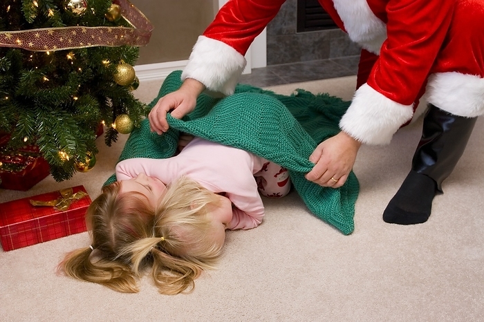 Santa Putting A Blanket Over Two Sleeping Kids, by Steve Nagy / Design Pics