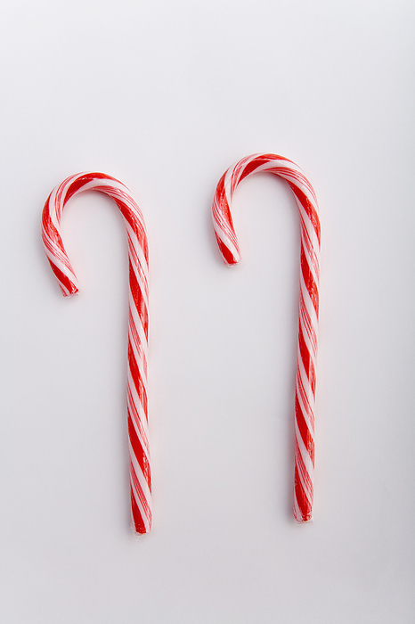 Two Stripped Christmas Candy Canes On White Background Studio Portrait, by Kevin G. Smith / Design Pics